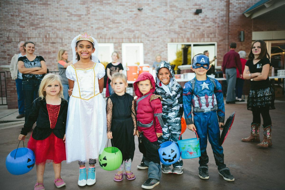line of kids in costumes at a trick or treat event