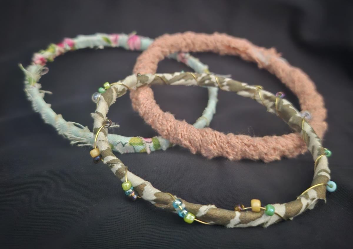 trio of bracelets made of fabric, wire, and beads