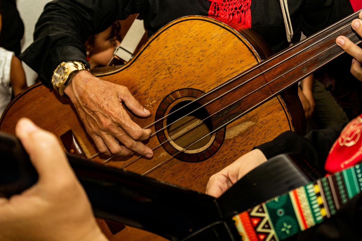 close up view of a large guitar being played by a mariachi band member