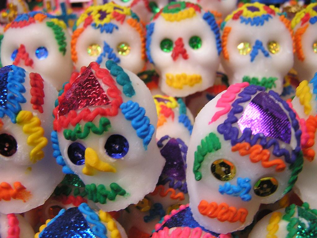 White candy skulls made of sugar are decorated with colorful icing.