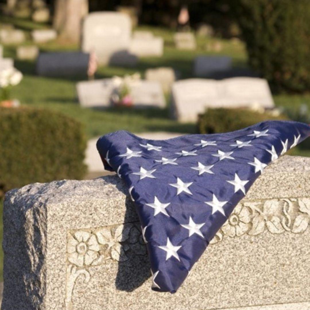 a folded veterans flag on a gravestone
