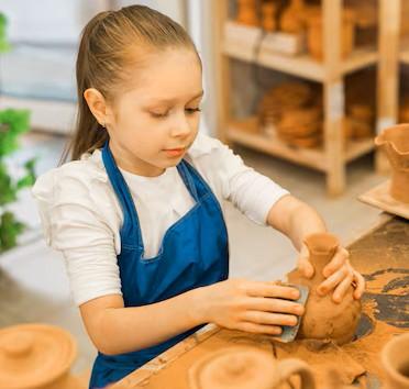 Child creating pottery